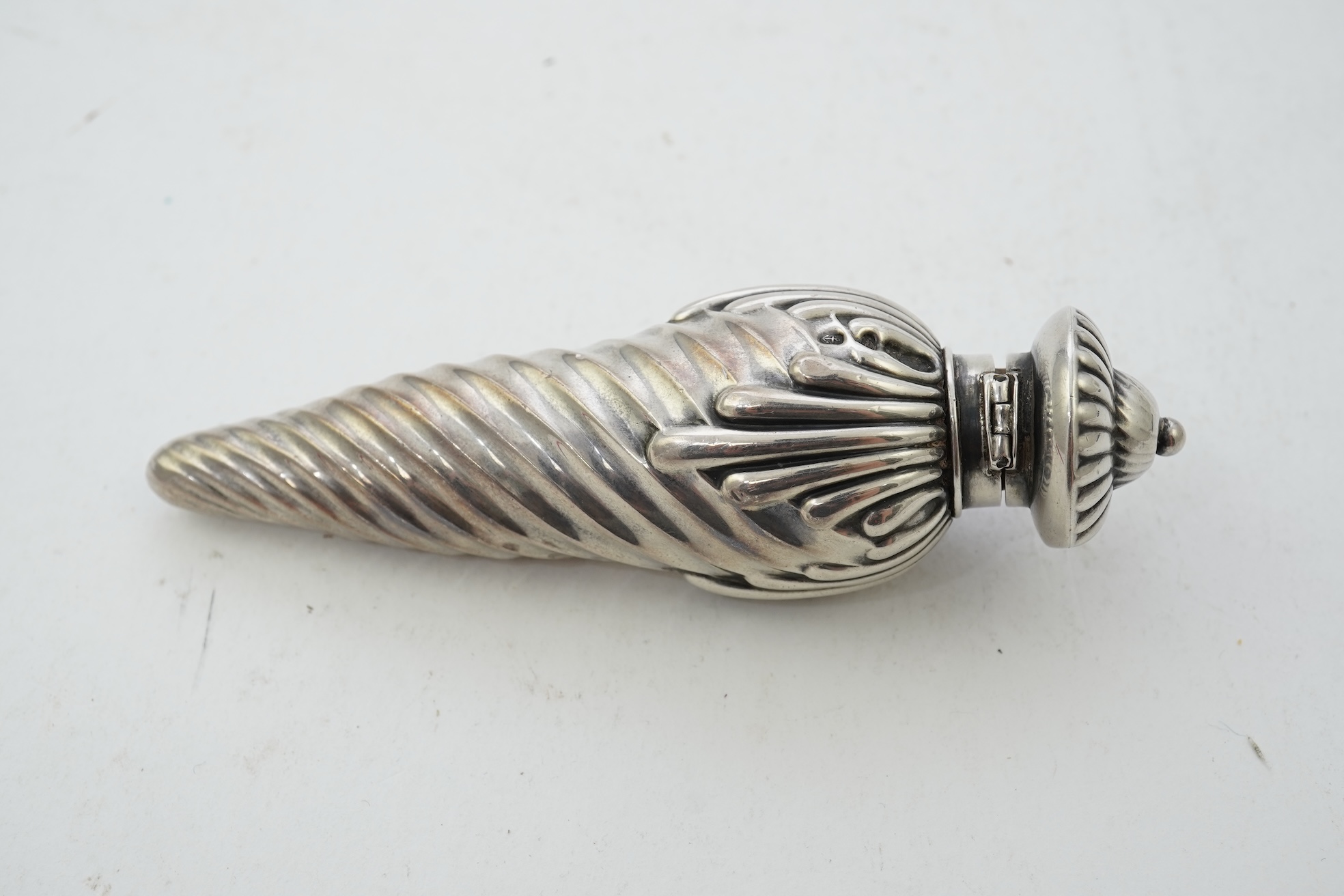 A late Victorian silver scent flask, of spiral tear drop form, with hinged cover and glass stopper